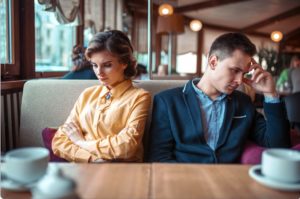 Couple struggling with communication in a restaurant, illustrating the mind-reading myth in relationships