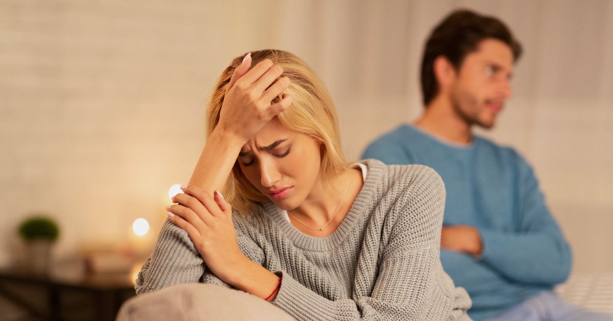 A couple sitting apart, looking frustrated—symbolizing unspoken expectations. A couple sitting apart, looking frustrated—symbolizing unspoken expectations.